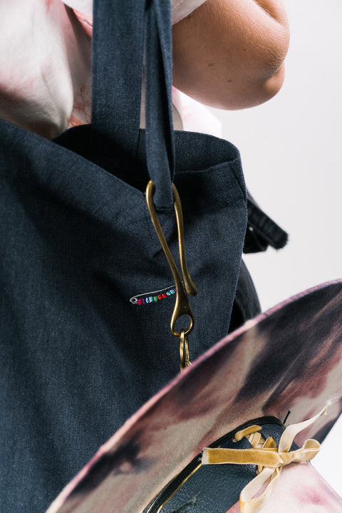 Marcel Rodrigues handcrafted brass keyhook, made-to-measure in premium brass. Shown demonstrating it can attach a Marcel Rodrigues bespoke fedora to a handcrafted tote bag.